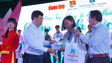 Bí thư Tỉnh ủy Đồng Tháp Lê Quốc Phong và Phó Tổng Biên tập Báo Tuổi Trẻ Nguyễn Hoàng Nguyên trao học bổng, quà cho học sinh. (Ảnh: HỮU NGHĨA)