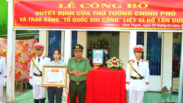 Đại tá Nguyễn Văn Hiểu, Giám đốc Công an tỉnh Đồng Tháp trao Bằng “Tổ quốc ghi công” cho vợ Liệt sĩ Hồ Tấn Dương.