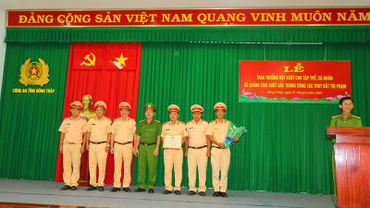 Lãnh đạo Công an huyện Cái Bè, tỉnh Tiền Giang và lãnh đạo Phòng Cảnh sát giao thông, Công an tỉnh Đồng Tháp trao giấy khen cho tập thể có thành tích trong bắt các đối tượng cướp và cố ý gây thương tích. (Ảnh: PHƯỚC THANH)
