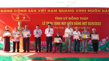 Bí thư Tỉnh ủy Đồng Tháp Lê Quốc Phong trao Huy hiệu Đảng cho các đảng viên. (Ảnh: HỮU NGHĨA)