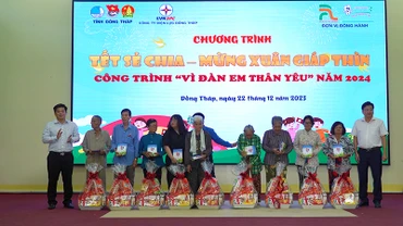 Chủ tịch Ủy ban nhân dân huyện Tháp Mười Đoàn Thanh Bình và Phó Giám đốc Công ty Điện lực Đồng Tháp Nguyễn Chí Thanh trao tặng quà. (Ảnh: HỮU NGHĨA)