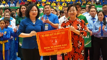 Thứ trưởng Giáo dục và Đào tạo Ngô Thị Minh trao cờ lưu niệm cho Giám đốc Sở Giáo dục và Đào tạo Nguyễn Thúy Hà, đại diện địa phương đăng cai