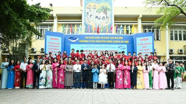 Hai Phu nhân chụp ảnh lưu niệm tại sân trường cùng Ban Giám hiệu và các em học sinh Trường phổ thông cơ sở Nguyễn Đình Chiểu.