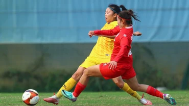 Huỳnh Như (áo vàng) tranh bóng cùng cầu thủ Than Khoáng sản Việt Nam. (Ảnh: VFF)