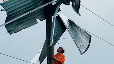 Công nhân Điện lực Bát Xát (Lào Cai) gỡ mái tôn khỏi cột điện.