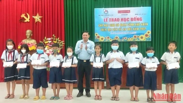 Chủ tịch Hội Nhà báo tỉnh Bến Tre Nguyễn Hữu Thọ trao học bổng cho học sinh nghèo, học giỏi.