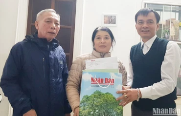 Bí thư Chi bộ Khu phố 5, phường 5, thành phố Đông Hà (bên trái) tặng các ấn phẩm Báo Nhân Dân cho bạn đọc nhân dịp Tết Quý Mão 2023.