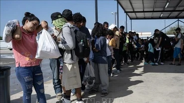 Người di cư chờ lên xe buýt để được trung chuyển khỏi bang Texas, Mỹ. (Ảnh minh họa: AFP/TTXVN)