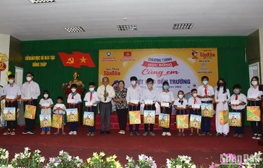 Đại biểu trao học bổng “Cùng em vượt khó đến trường”. (Ảnh: HỮU NGHĨA)