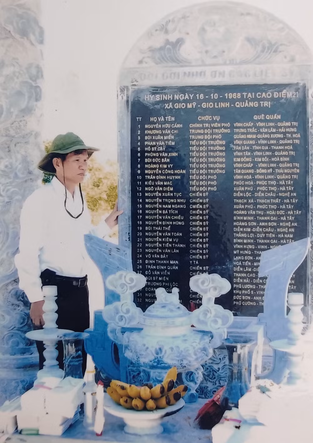 Ông Hoàng Ngọc Bích bên tấm bia ghi danh sách các đồng đội ngã xuống tại chiến trường Quảng Trị. Ảnh: NVCC