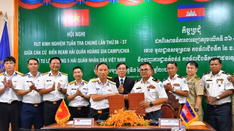 Chuẩn Đô đốc Ngô Văn Thành, Chính ủy Bộ Tư lệnh Vùng 5 Hải quân và Phó Đô đốc May Dina, Chỉ huy trưởng Căn cứ biển Ream trao biên bản ghi nhớ công tác phối hợp. (Ảnh: TRẦN KIÊN)