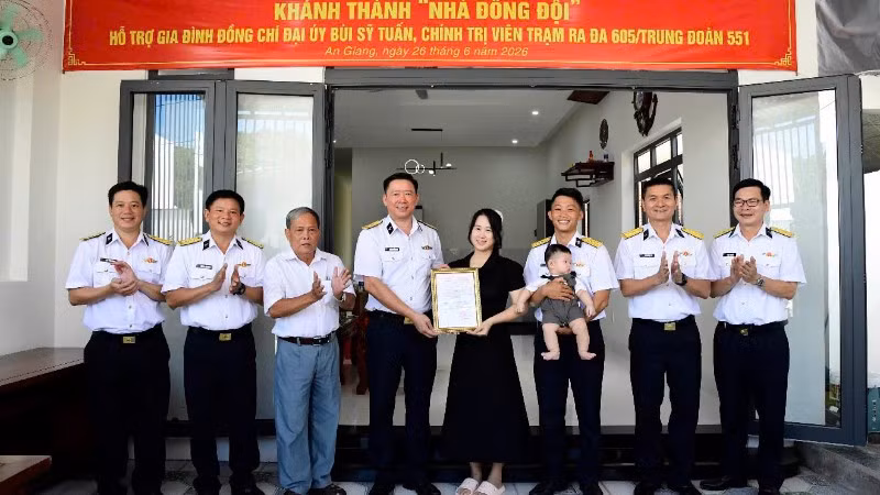 Đại tá Hoàng Quốc Hoàn, Phó Chính ủy Vùng 5 Hải quân trao quyết định hỗ trợ kinh phí xây dựng nhà đồng đội cho gia đình Đại úy Bùi Sỹ Tuấn. (Ảnh do Vùng 5 Hải quân cung cấp) 