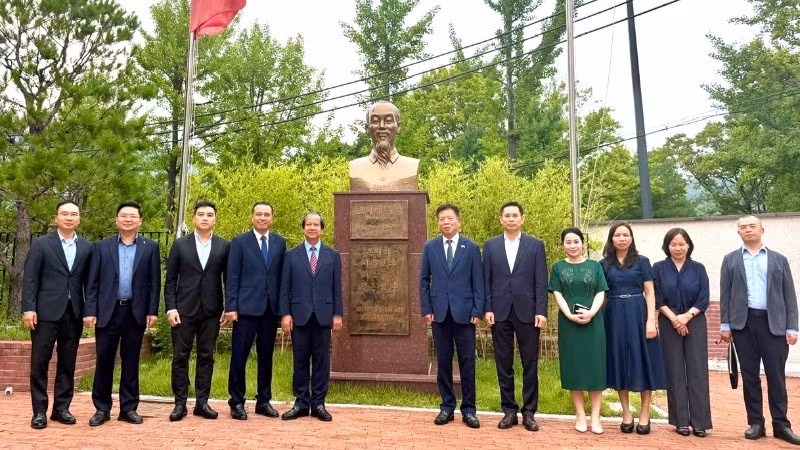 Đoàn công tác chụp ảnh cùng Đại sứ Vũ Hồ và cán bộ Đại sứ quán bên Tượng đài Chủ tịch Hồ Chí Minh trong khuôn viên Đại sứ quán. 