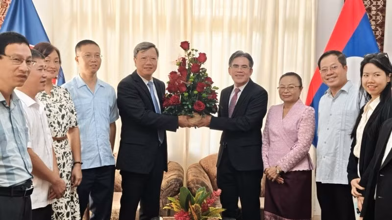 Đại sứ Lê Quang Long tặng hoa chúc mừng Đại sứ Vanhtha Sengmeuang và toàn thể cán bộ nhân viên Đại sứ quán Lào. (Ảnh: Đại sứ quán Việt Nam tại Cuba)