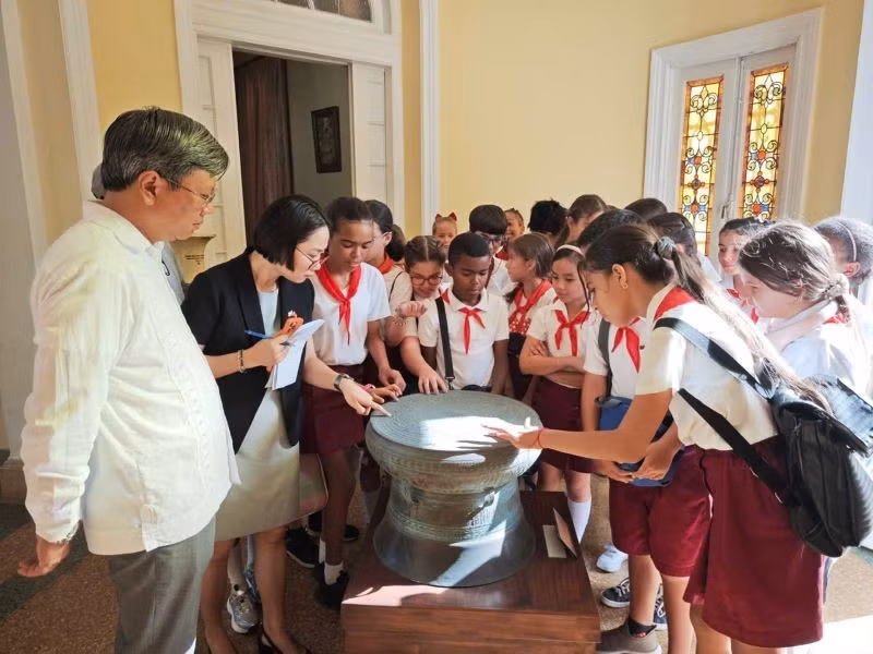 Các em học sinh thích thú khám phá mô hình Trống Đồng-biểu tượng của văn hóa Việt Nam. (Ảnh: Đại sứ quán Việt Nam tại Cuba)