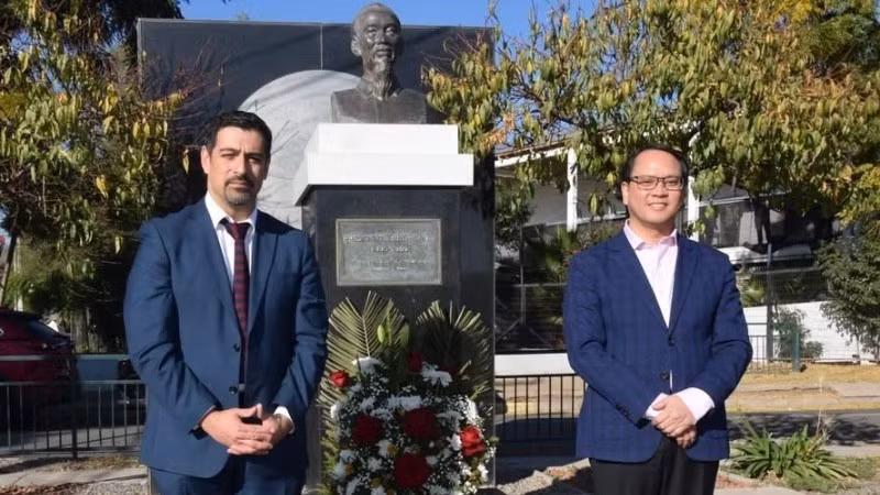 Đại sứ Nguyễn Việt Cường và ông Mauro Tamayo Rozas, Quận trưởng Cerro Navia dâng hoa và chụp ảnh kỷ niệm tại tượng Chủ tịch Hồ Chí Minh. (Ảnh do Đại sứ quán Việt Nam tại Chile)