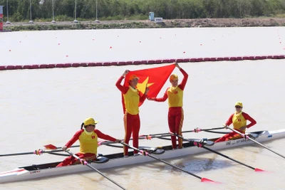 Các tay chèo Việt Nam tự hào giương cao quốc kỳ sau khi cán đích về nhất. 