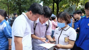 Thí sinh trao đổi sau buổi thi Ngữ văn sáng 26/6 (Ảnh: HỒNG VÂN)