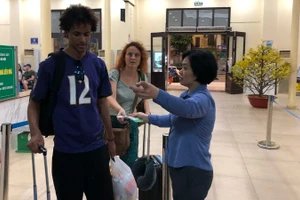 Nhân viên khách vận hướng dẫn hành khách vào ga đi tàu.