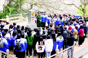 Học sinh Trường trung học phổ thông Đồng Đăng lắng nghe chiến sĩ Đồn Biên phòng Cửa khẩu Hữu Nghị giới thiệu về cột mốc quốc giới số 1116.