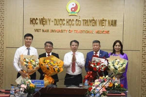 Phó Giáo sư, Tiến sĩ Nguyễn Quốc Huy, Giám đốc Học viện Y-Dược học cổ truyền Việt Nam trao Quyết định và tặng hoa cho các Phó Giáo sư tại buổi lễ.
