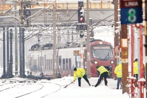 Công nhân dọn tuyết tại ga xe lửa ở Bucharest, Romania. (Ảnh: TÂN HOA XÃ)