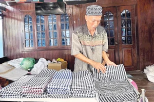 Nghệ nhân Mohamad giới thiệu các sản phẩm dệt truyền thống của người Chăm.