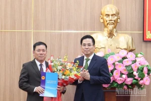 Chủ tịch Ủy ban nhân dân tỉnh Quảng Ngãi Nguyễn Hoàng Giang trao quyết định và tặng hoa chúc mừng đồng chí Nguyễn Văn Trọng.