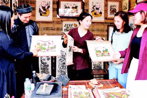 Nghệ nhân tranh dân gian Đông Hồ giới thiệu tác phẩm với du khách tại Festival “Về miền di sản Bắc Ninh-2026”.