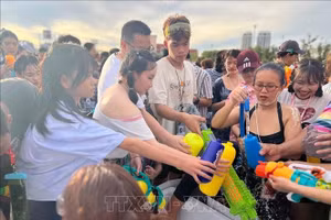 Người tham gia lễ hội chờ lấy nước để té vào nhau - một trong những điểm nổi bật của lễ hội Songkran. (Ảnh tư liệu: Huy Tiến/TTXVN)