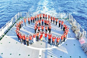 Kiều bào chụp ảnh lưu niệm trên tàu KN390 trong chuyến thăm Trường Sa. (Ảnh: Ủy ban Nhà nước về người Việt Nam ở nước ngoài)