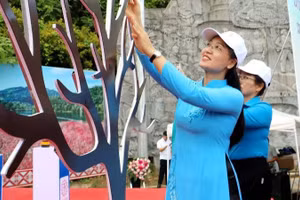 Lãnh đạo Hội Liên hiệp Phụ nữ tỉnh Điện Biên gửi thông điệp yêu thương, bảo vệ phụ nữ, trẻ em gái bằng cách phòng chống bạo lực gia đình trên "cây yêu thương". (Ảnh: LAN PHƯƠNG)