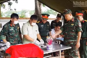 Đại tá Dương Quốc Long, Phó Chính ủy Bộ Chỉ huy quân sự tỉnh Điện Biên thăm, kiểm tra việc thực hiện các quy trình lấy mẫu hài cốt liệt sĩ tại Nghĩa trang liệt sĩ Độc Lập. 