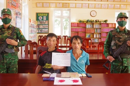 Hai đối tượng gồm Giàng A Vàng và Lý A Giàng cùng tang vật khi bị bắt giữ. (Ảnh: ANH DŨNG)