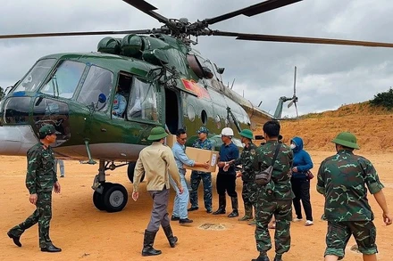 Các lực lượng địa phương tiếp nhận hàng cứu trợ từ trực thăng vận chuyển về xã Tìa Dình, tỉnh Điện Biên. (Ảnh: LAN ANH)