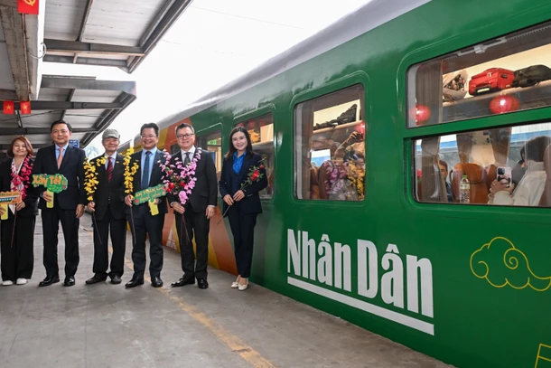 Các đại biểu tại "Chuyến tàu hạnh phúc", chuyến tàu đặc biệt có in logo của Báo Nhân Dân.