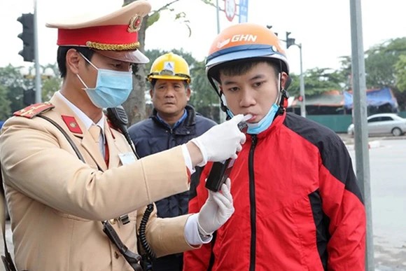 Cảnh sát giao thông Hà Nội kiểm tra nồng độ cồn theo đúng quy định của Bộ Y tế. Ảnh: VIỆT CƯỜNG