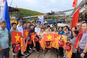 Đại diện Bộ Tư lệnh Vùng Cảnh sát biển 3 và Ban Tuyên giáo và Dân vận Tỉnh ủy Vĩnh Long tặng cờ Tổ quốc, áo phao, túi thuốc y tế... cho ngư dân.