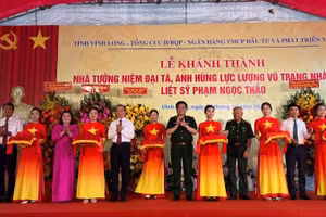 Đại biểu tham dự buổi lễ thực hiện nghi thức cắt băng khánh thành công trình. (Ảnh: HOÀNG TRUNG)