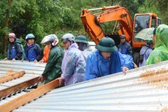Các lực lượng thu dọn tại khu vực sạt lở.