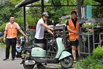 Nhân viên hướng dẫn người dân đưa xe điện vào điểm sạc pin tập trung ở thành phố Giao Châu, Thanh Đảo, tỉnh Sơn Đông, Trung Quốc. (Ảnh: Tân Hoa xã)