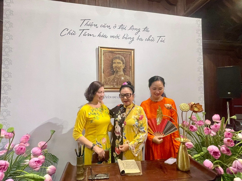 Khách tham quan chụp ảnh trước bức chân dung đại thi hào Nguyễn Du được chế tác từ lá sen khô. z6688407883483-32e74ece433a31bca11670c20b27906f.jpg