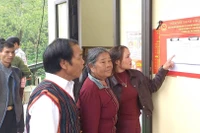 Cử tri bản Hôi Rấy, xã Trường Sơn (khu vực bỏ phiếu số 16) xem danh sách cử tri tại nhà văn hóa bản.