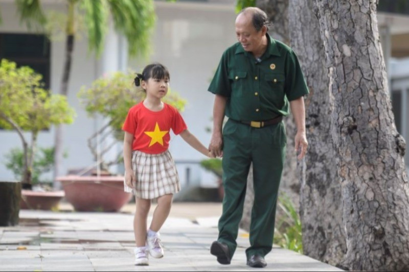 Thượng sĩ Nguyễn Chí Tường cùng con một nhân viên Vinamilk tại Trung tâm Điều dưỡng Thương binh và Người có công Long Đất. (Ảnh: THANH BÌNH) anh-1-7619.jpg