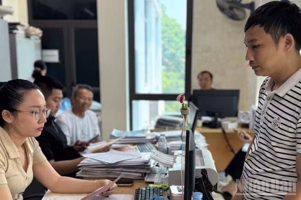 Cán bộ Văn phòng Đăng ký đất đai phường Yên Bái thẩm định kết quả và trả giấy chứng nhận quyền sử dụng đất cho công dân trong phường. (Ảnh: THANH SƠN)