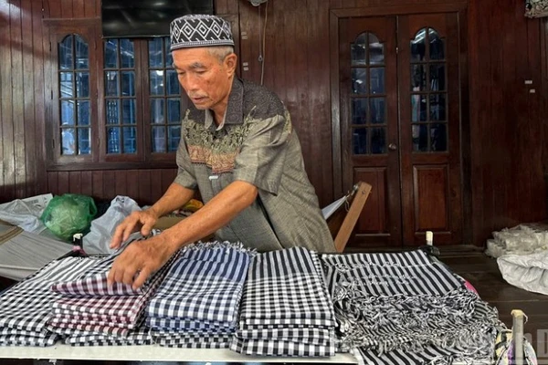 Ông Mohamad chăm chút cho từng sản phẩm dệt trưng bày tại cửa hàng.