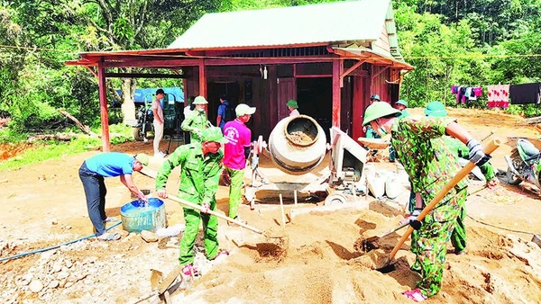 Cán bộ, chiến sĩ Đồn Biên phòng Đắc Pring giúp người dân vùng biên xây dựng nhà mới.
