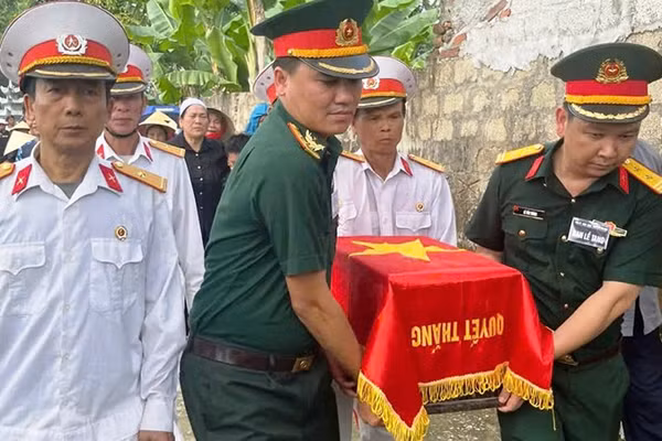 Lực lượng vũ trang cùng các cựu chiến binh di chuyển hài cốt liệt sĩ.