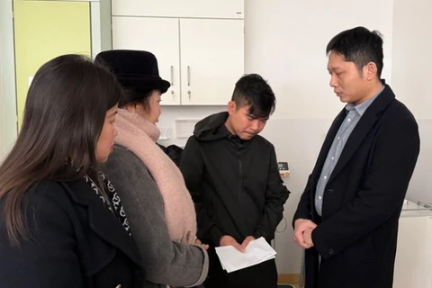 Tham tán Vũ Sơn Tùng (ngoài cùng, bên phải) thăm hỏi và động viên anh Nguyễn Hồng K. (Ảnh: Thu Hằng/TTXVN)