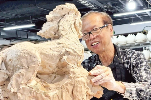 Nhà điêu khắc Nguyễn Kim Xuân bên một tác phẩm dành cho năm Bính Ngọ 2026.